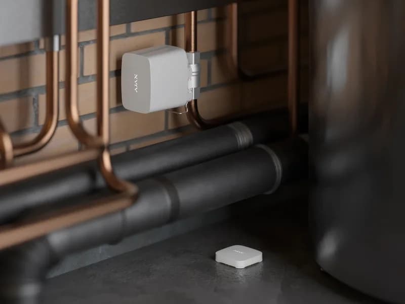Кран Ajax WaterStop на трубі опалення та датчик LeaksProtect на підлозі технічного приміщення