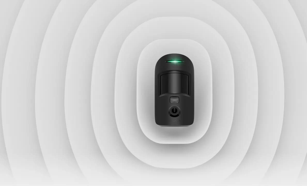 Чорний датчик руху з камерою Ajax MotionCam на світлому тлі