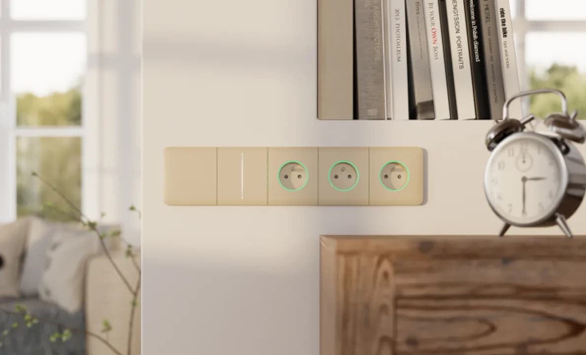 Сенсорні вимикачі Ajax LightSwitch і розетки Outlet в одній бежевій рамці на стіні
