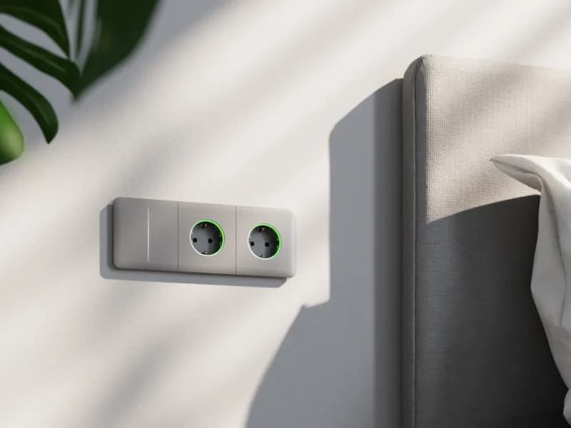 Вимикач Ajax LightSwitch і дві розетки Outlet у сірій рамці біля ліжка